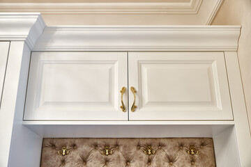 Classic white wardrobe with seating in contemporary bright hallway. Carriage coupler closet bench