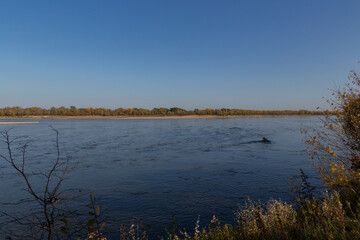 view of the Vistula river with blue water on a background of blue sky in autumn