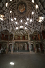 Kashan, Iran, Wonderful view of colorful hall inside Tabatabaei Historical House. Traditional Iranian stained glass windows. Amazing Persian interior.