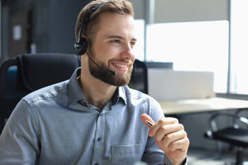 Smiling friendly handsome young male call centre operator.