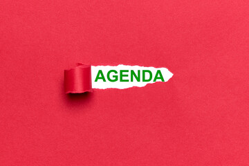 Background of a broken red cardboard showing the word AGENDA