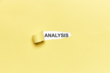 Broken yellow cardboard with the word ANALYSIS. With copy space