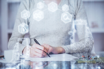 Technology theme hologram over woman's hands taking notes background. Concept of Tech. Double exposure