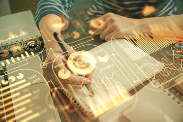 Tech theme hologram over woman's hands taking notes background. Concept of hightech. Double exposure