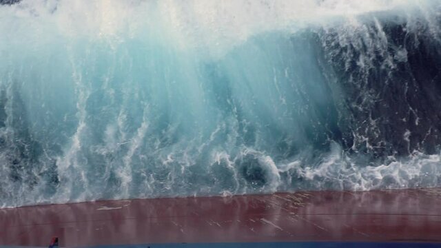 Wave splashing against ships red board.