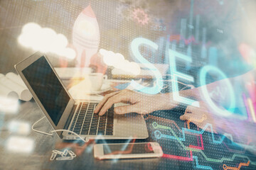 Double exposure of seo icon with man working on computer on background. Concept of search engine optimization.