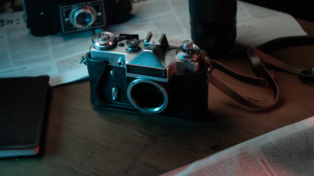 Old school, vintage camera and lenses, journalism style with notebooks and newspapers