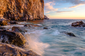 Fototapeta na wymiar Golden sunlight at sunrise on the cliffs of coastline.