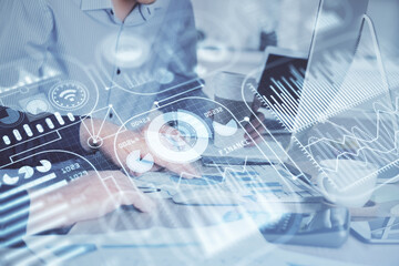 Technology theme hologram with man working on computer on background. High tech concept. Multi exposure.