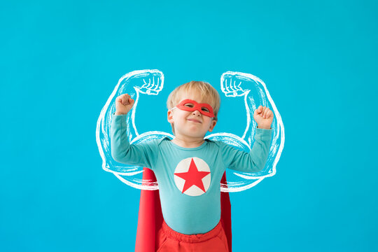 Portrait of superhero child against blue background