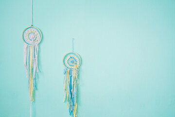 Tender dream catchers and ribbons on the background of a turquoise wall.