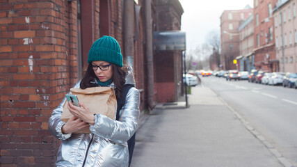 Takeaway food, a young woman with shopping in an eco-friendly paper bag.