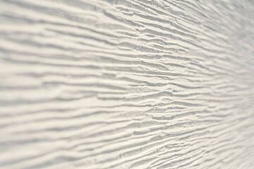 Textured white wall with horizontal lines, shot at an angle with blurring