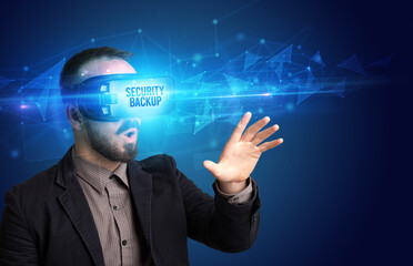 Businessman looking through Virtual Reality glasses with SECURITY BACKUP inscription, cyber security concept