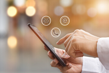 Close-up image of man hands using mobile smartphone with ( mail, phone, email ) icon. Contact us connection and social networks concept