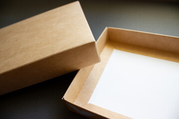 Open cardboard box close-up on a dark background. The concept of wrapping gifts.