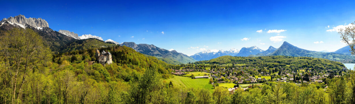 Wide pastoral view of  Alps, hills, meadows and villages surrounding Lake Annecy. View of the Castle of Menthon-Saint-Bernard (Ch&acirc;teau de Menthon-Saint-Bernard)