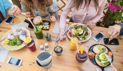 Young people eating brunch and drinking smoothie bowl at vintage bar - Happy people having a...