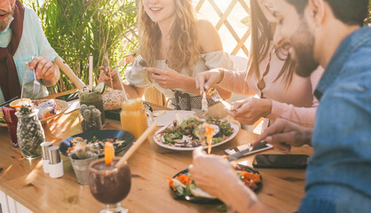 Young people eating brunch and drinking smoothies bowl with ecological straws in trendy bar...