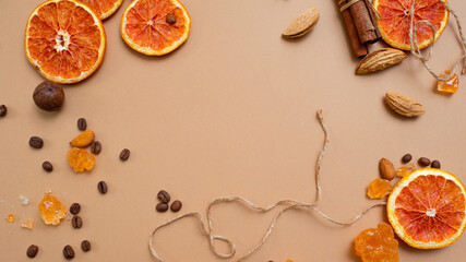 Citrus and spicy background with coffee beans and spices, warm ochre background