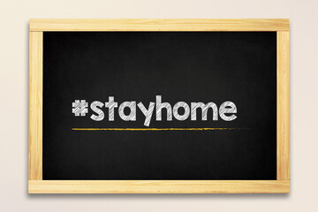 Stay home hashtag made in chalk on blackboard