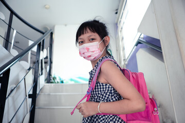 Asian child girl wearing face mask going back to school after covid-19 quarantine and lockdown