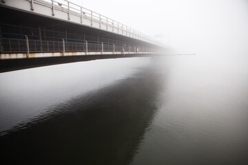 Bridge side view with reflection in the water  . Donaubrucke in the foggy morning