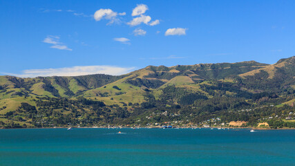 Fototapeta na wymiar Panoramic view of the town of Akaroa, New Zealand, and the surrounding hills, seen from the harbor