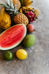 Fresh healthy tropical fruits, melon, pineapple, mango, bananas, dragon fruit Summer food vitamins concept