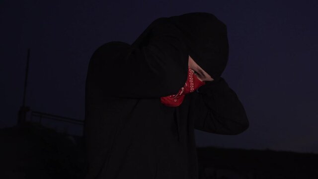 a man ties a bandana at night
