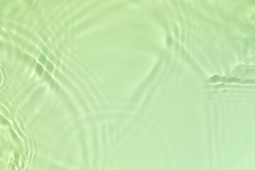 Closeup of mint green transparent clear calm water surface texture with splashes and bubbles. Trendy abstract summer nature background. Mint colored waves in sunlight. Copy space.