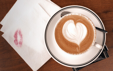 Close up coffee cup with latte art milk foam on wood table, top view