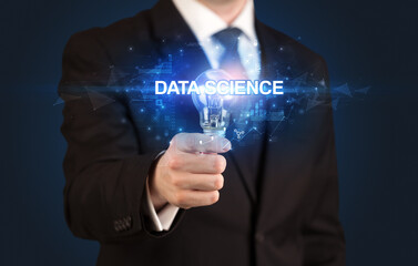 Fototapeta premium Businessman holding light bulb with DATA SCIENCE inscription, innovative technology concept