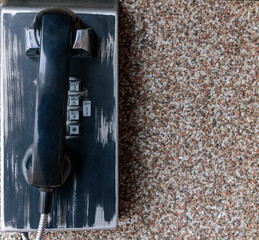 Old wall mounted telephone. Black case and handset. Scuffs and scratches. Metallic dial...