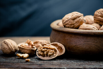 still life with Walnut kernels and whole walnuts on rustic old wooden table