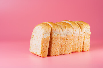 sliced whole wheat bread isolated on pink background