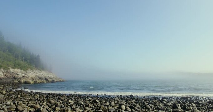 Waves Washing Against Rocky Beach As Fog Layer Approaches