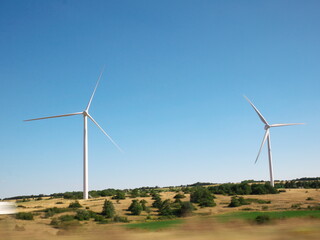 Fototapeta na wymiar Wind turbine landscape in a field on a sunny summer day