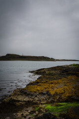 Rocky coastline in Oban bay on a stormy sunrise, Scotland