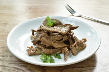  fried slice pork liver with garlic and pepper topping parsley on plate