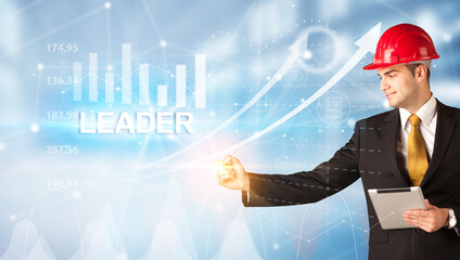 Young businessman with helmet drawing LEADER inscription, modern business technology concept