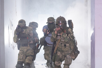 Fototapeta premium Airsoft team make a takeover of a building in smoke