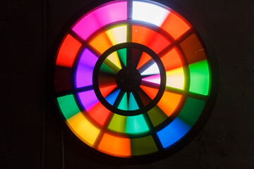 Round stained glass window made of multicolored glass on dark background. circle shape stained...