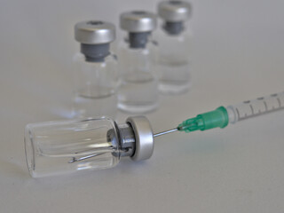 Vaccine bottles and syringe with injection fluid and aluminium caps_Green syringe