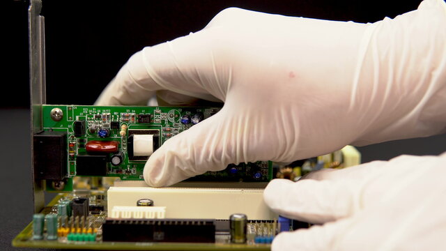 Removing a network card from the motherboard. Network data transmission system via wire. Many different chips. View of the computer parsed