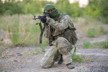 Sniper with rifle posing. Airsoft game