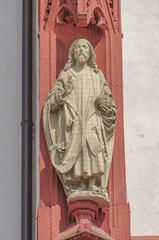 Fototapeta na wymiar Ancient wall sculpture of a monk at the main facade of Mary chapel in historical downtown of Wurzburg, Germany