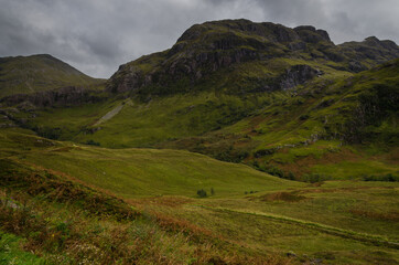 Mountain landscape in the Glen Coe with dark clouds hanging over the peaks, Highland, Scotland