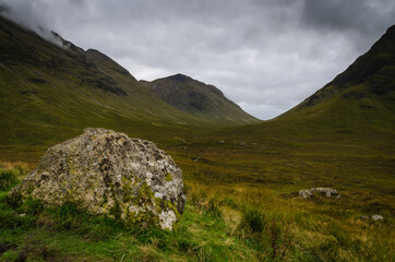 Mountain landscape in the Glen Coe with dark clouds hanging over the peaks, Highland, Scotland