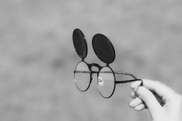 Steampunk sunglasses model held in hand with round lenses retro flip up model close up shoot in a...
